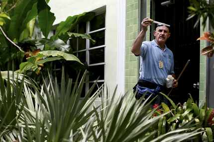 An inspector checks an area of standing water, which can be a breeding ground for...