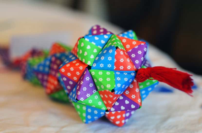 Each of the girls’ origami ornaments takes several hours to complete and is made in the...