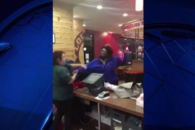 A woman takes a swing at a Popeyes employee in Fort Worth in this still image from...