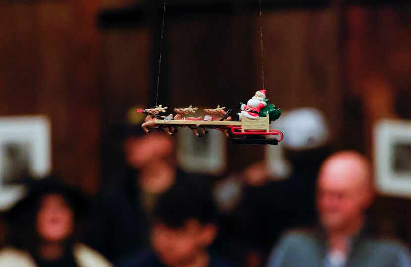 Santa Claus and his reindeer circle above the train exhibit with the help of an apparatus...