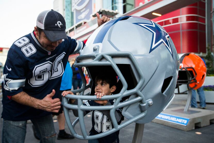 Dallas Cowboys fan Jose Luis Candia of Houston gives a thumbs up to his son Jacob, 5, as he...