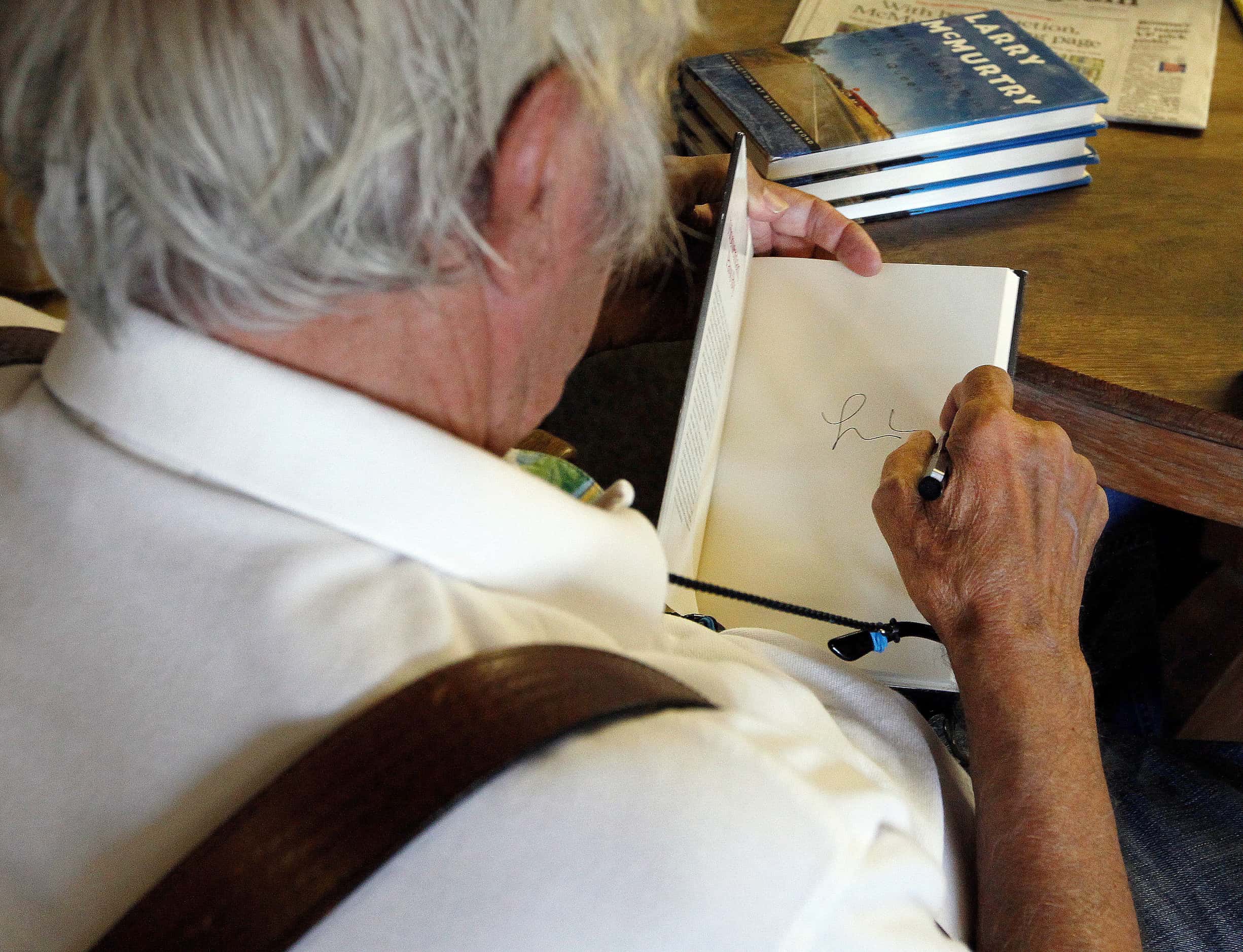 Larry McMurtry signs books for customers after his auction from his private collection in...