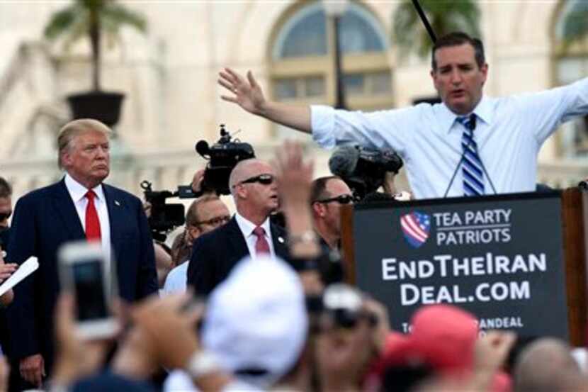  Republican Presidential candidate Donald Trump, second from left, listens as fellow...