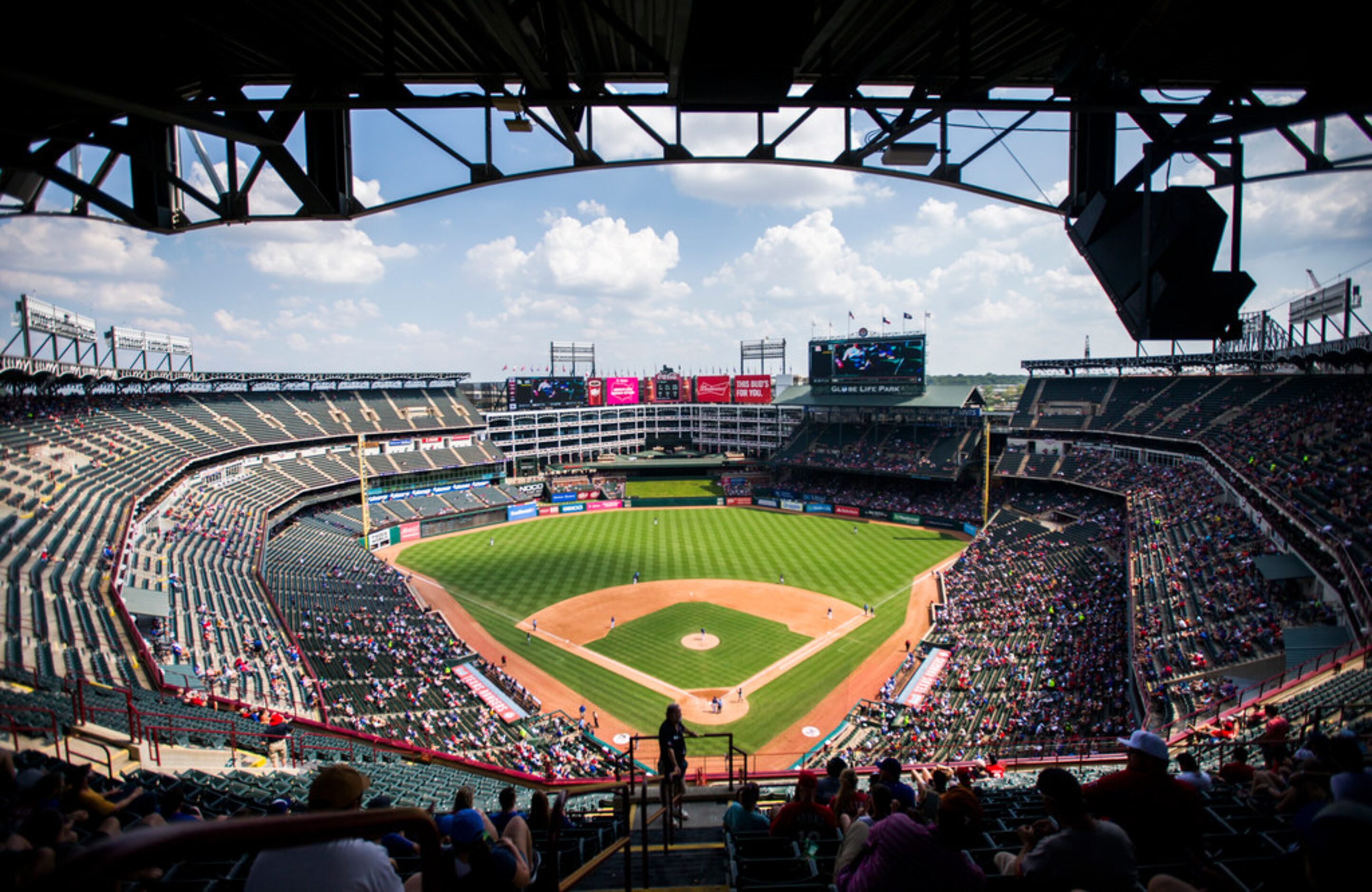 Sparse fans watch an MLB game between the Texas Rangers and the Seattle Mariners on Sunday,...