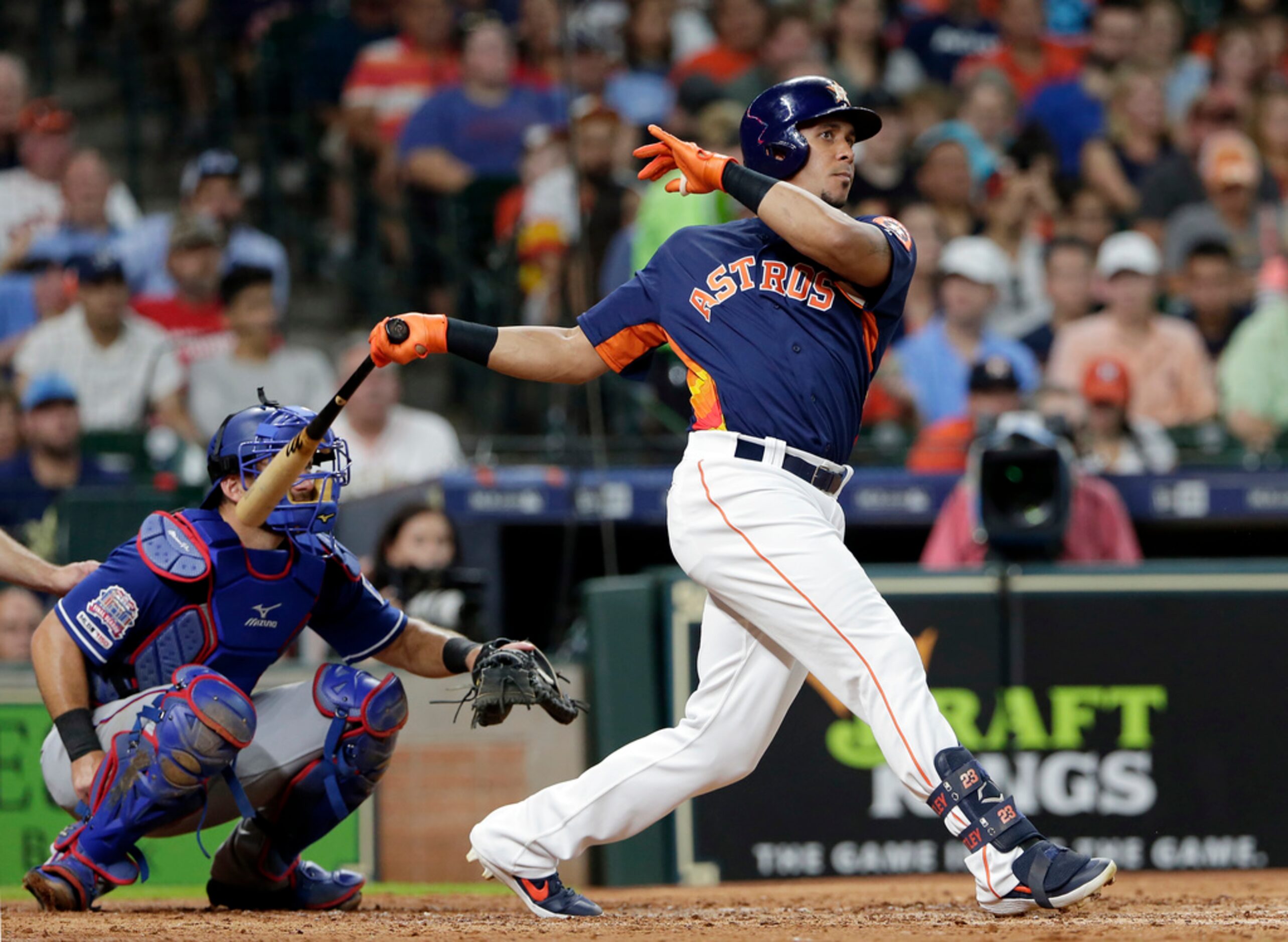 Houston Astros left fielder Michael Brantley, right, watches his hit for a single in front...