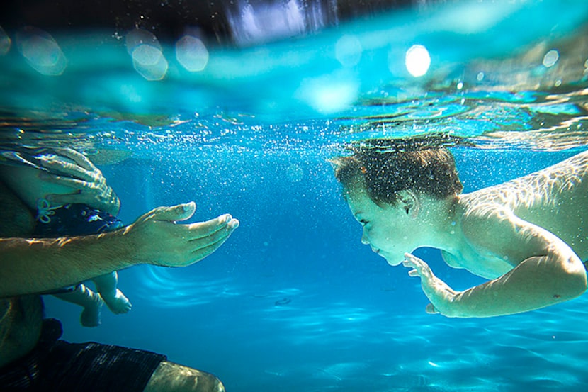  Shepherd Ricchuiti, 3, swims to his father Tim and brother Stone, 9 months, as they cool...