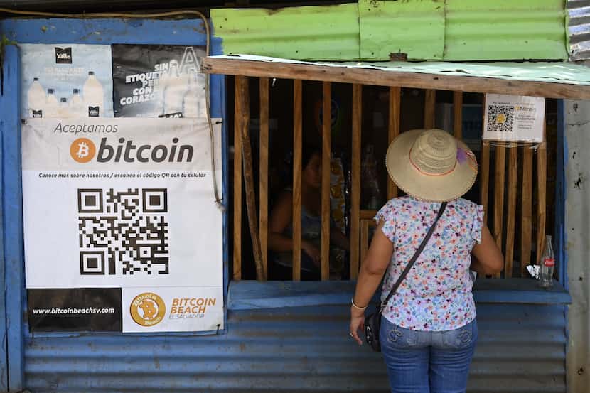 Una mujer se acerca a una tienda que acepta transacciones en Bitcoin en La Libertad, El...