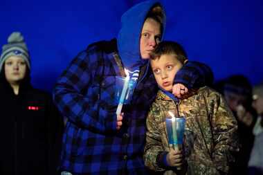 Local residents pray during a candlelight vigil following a shooting at Perry High School,...