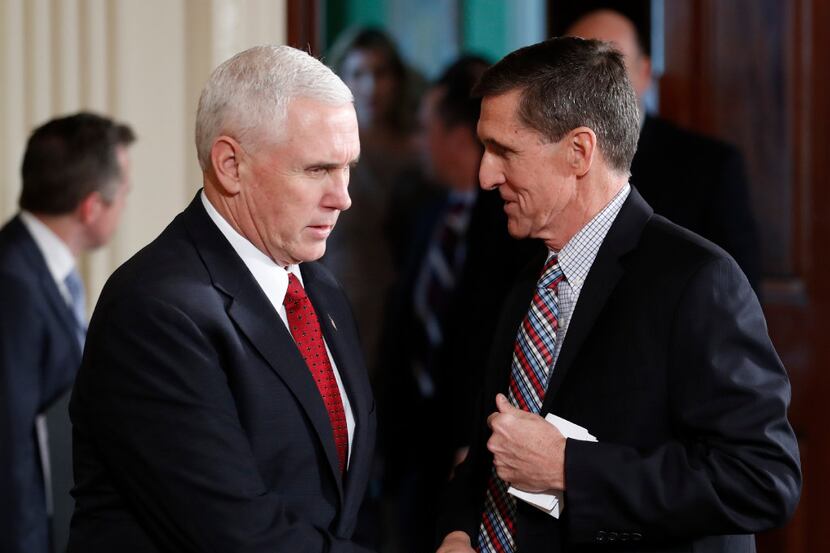 Vice President Mike Pence and National Security Adviser Michael Flynn, right, shake hands...