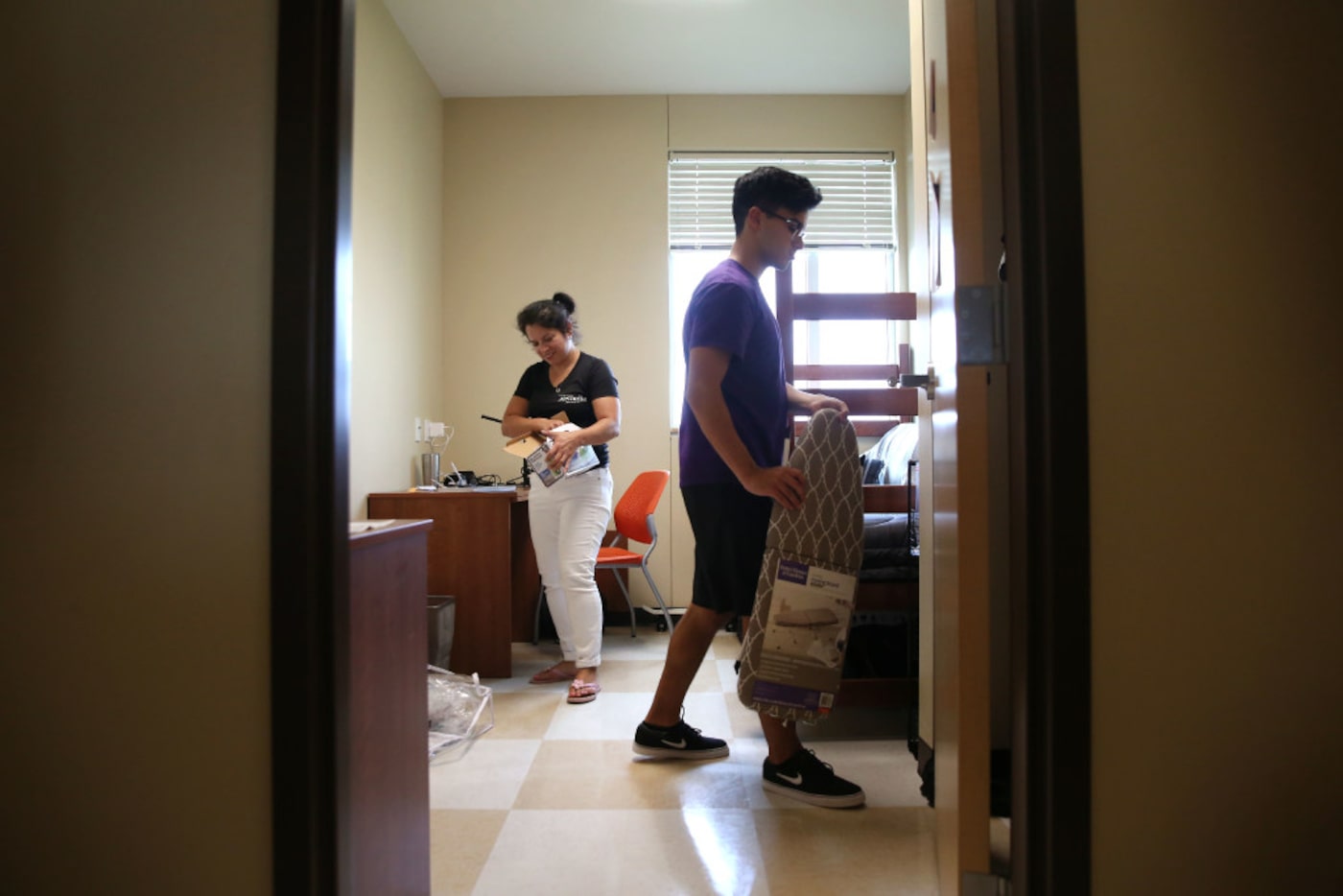 Erik Jimenez, 18, and his mom, Monica Jimenez, unpack his things in his new dorm during...