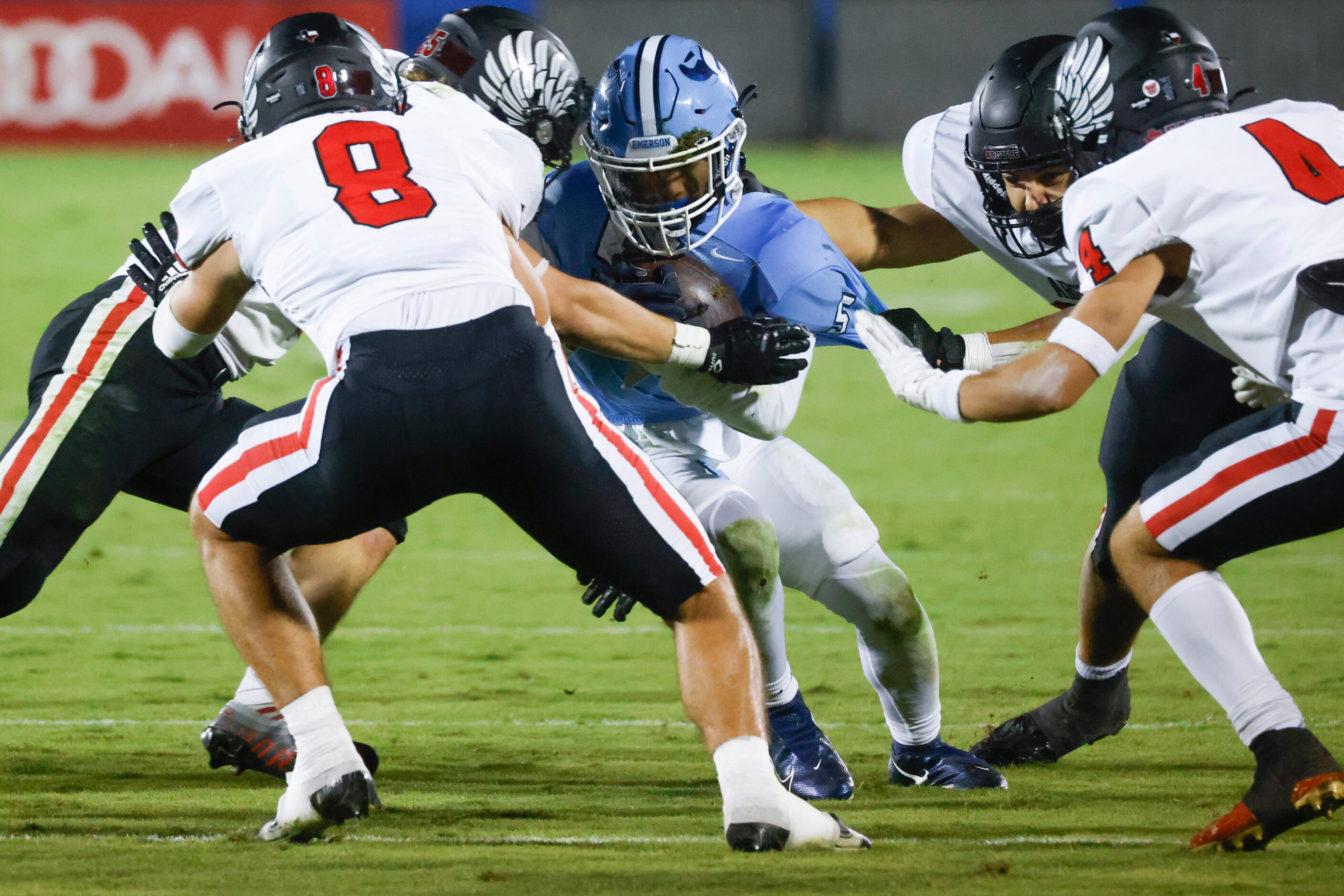 Emerson’s Bills Ishaqq (5), center, runs past Argyle high school’s defenders during the...