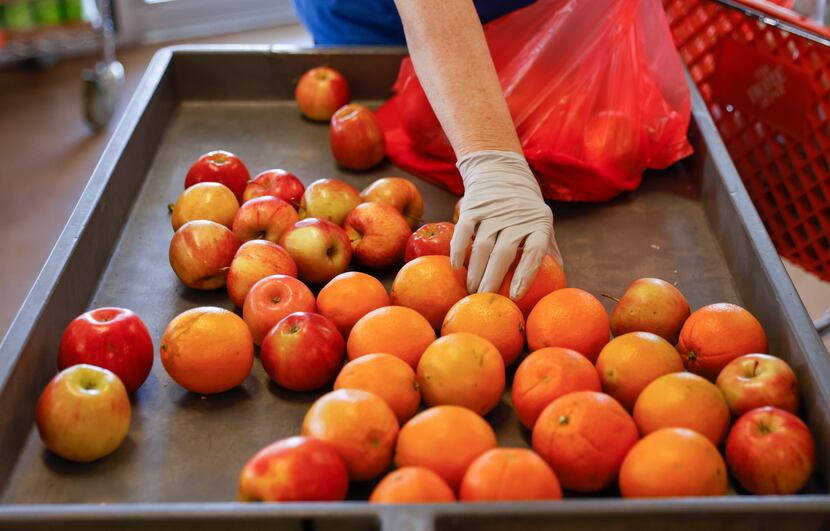 A volunteer bags fresh apples at Frisco Family Services.