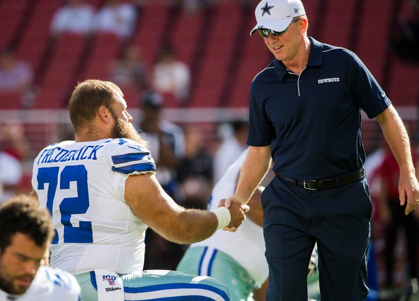 Dallas Cowboys head coach Jason Garrett shakes hands with center Travis Frederick (72)...