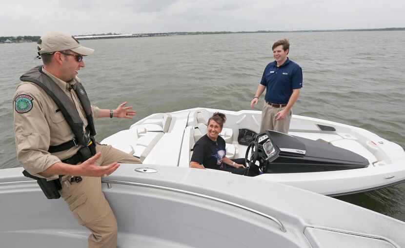 
Game warden Logan Griffin, talking Tuesday with boaters Teresa Theobald and Jacob Squires...