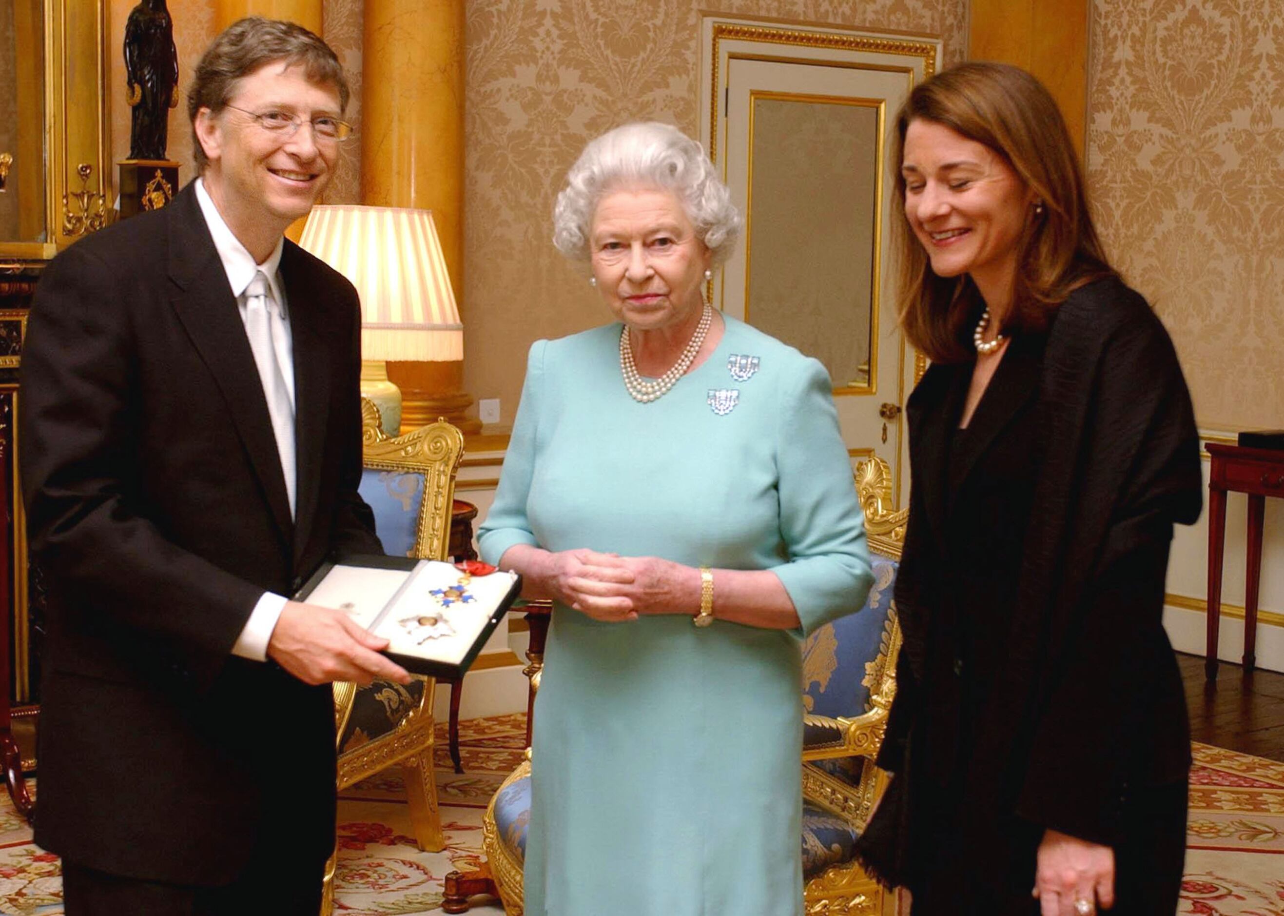 Britain's Queen Elizabeth II presents Microsoft tycoon Bill Gates with his honorary...