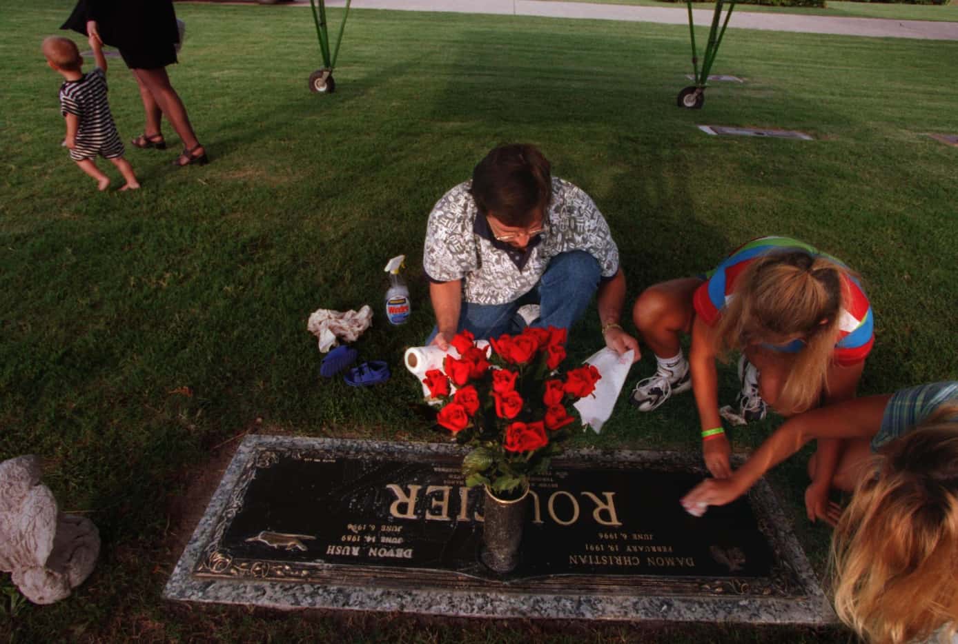 Darin Routier cleans the gravestone of his two slain sons, Devon and Damon, at Rest Haven...