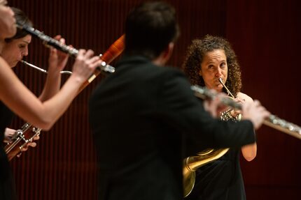 Anni Hochhalter, playing the horn, looks at her fellow members of WindSync during a concert...