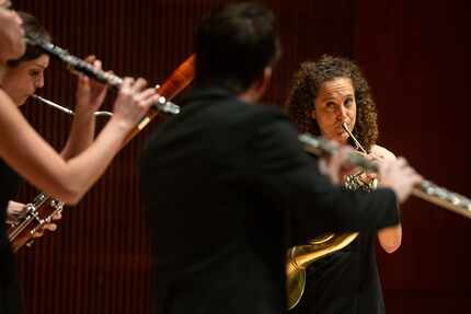 Anni Hochhalter, playing the horn, looks at her fellow members of WindSync during a concert...