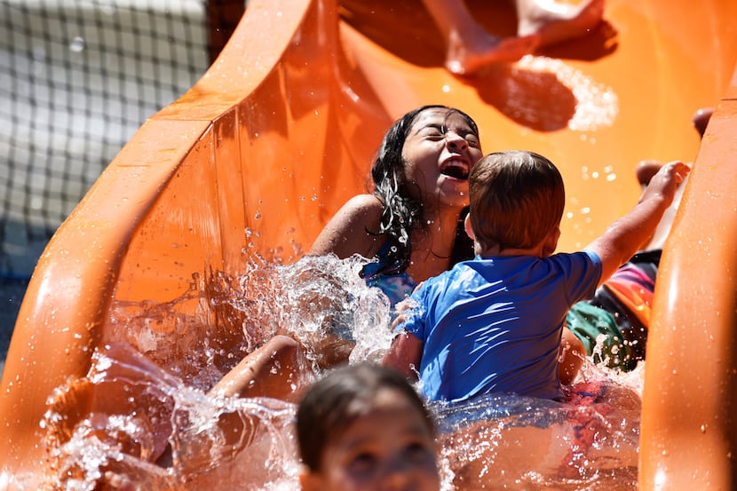 Isabella Zelaya, 10, splashes down a water slide while colliding with other kids at the Oak...