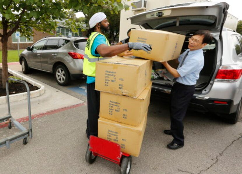 El voluntario Cason Bey, ayuda a Yeou Lil Lin Chi Li, de la Fundación Budista Tzu Chi con...