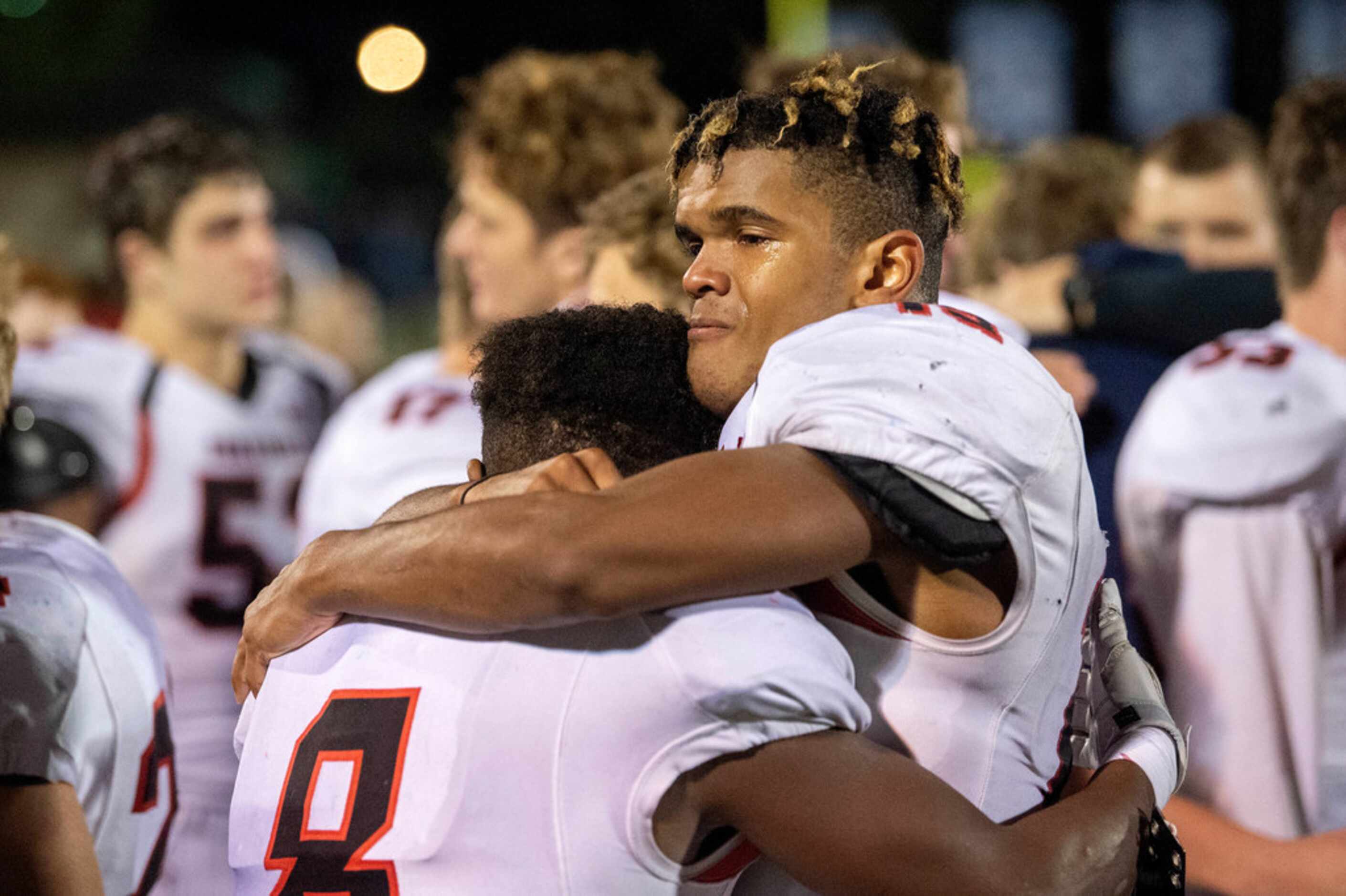Fort Worth Christian junior wide receiver Jamal Marshall (15) hugs senior linebacker Billy...