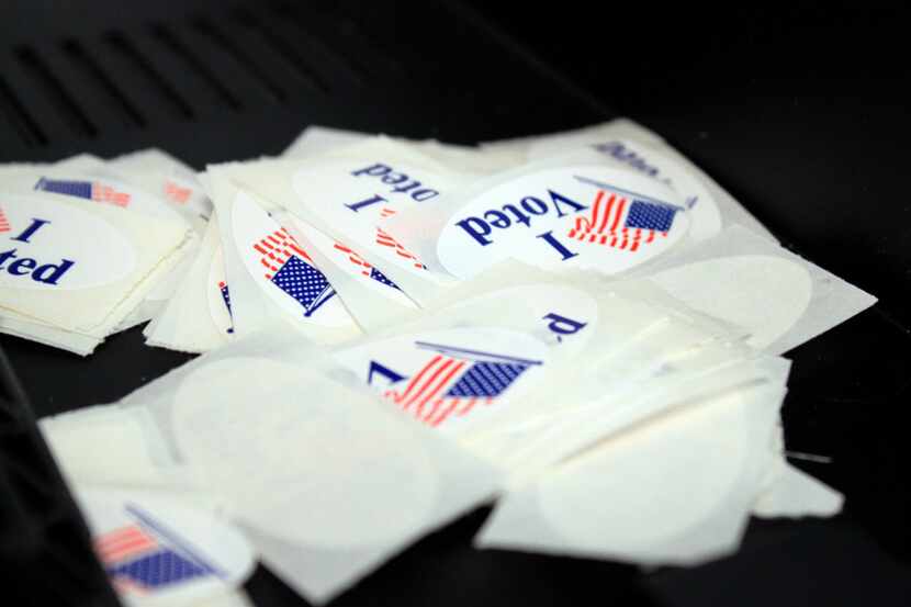 Voter stickers sit in a pile near a ballot machine at an early voting site.