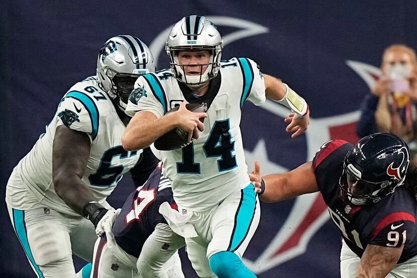 Carolina Panthers quarterback Sam Darnold (14) breaks away from Houston Texans defensive...