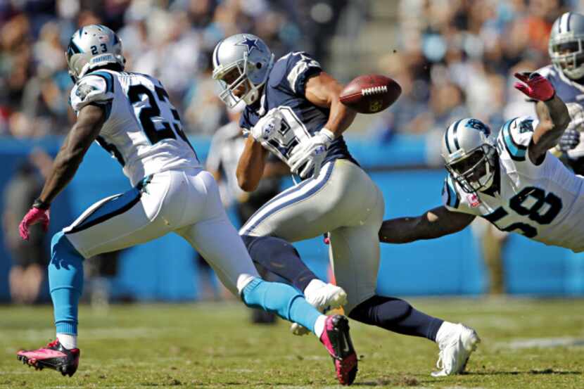 Dallas Cowboys wide receiver Miles Austin (19) loses control of the ball under pressure from...