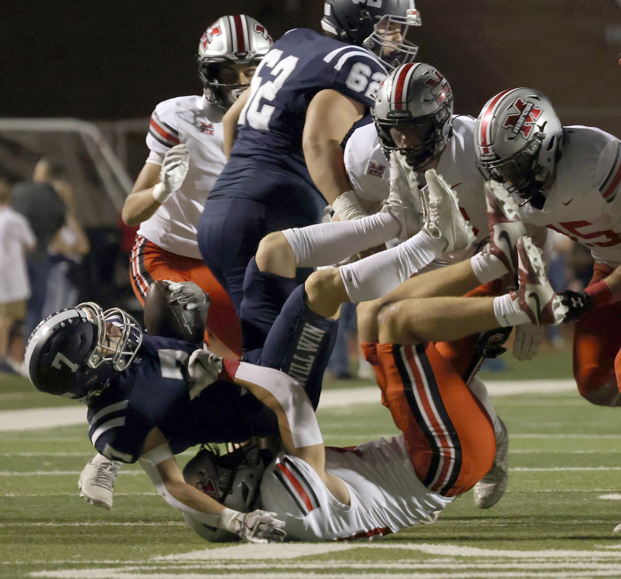 Flower Mound's Ryan Stadler (7), left, is pulled down for a 1-yard loss by Flower Mound...