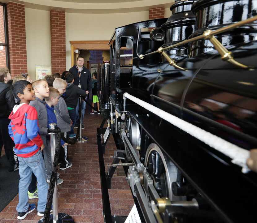 Third-graders from Frisco ISD's Tadlock Elementary look at the miniature steam locomotive as...