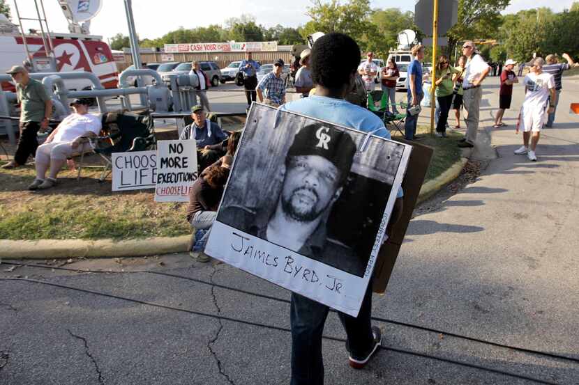 Ricky Jason wears a photograph of James Byrd Jr. outside the Texas Department of Criminal...