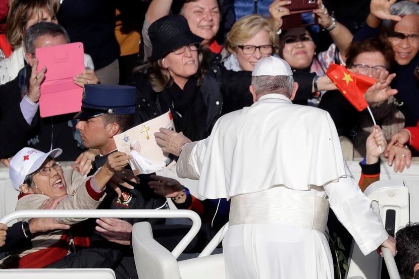 A worshipper presents Pope Francis with a picture of an imagined meeting between the pope...