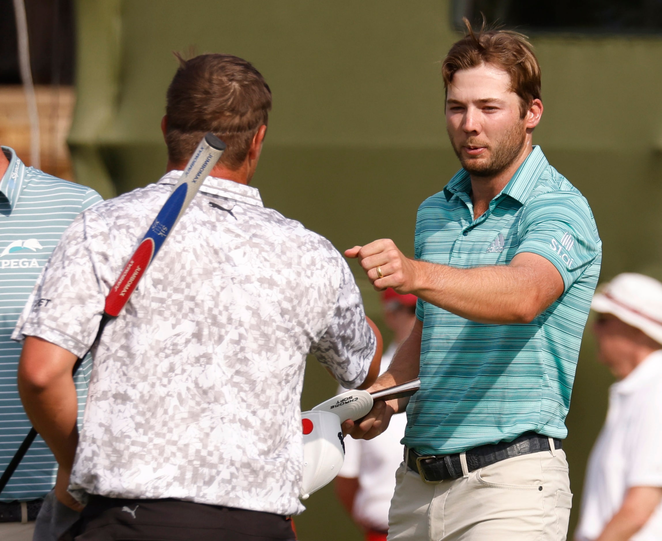 Sam Burns and Bryson DeChambeau bump fists after completing round 2 of the AT&T Byron Nelson...