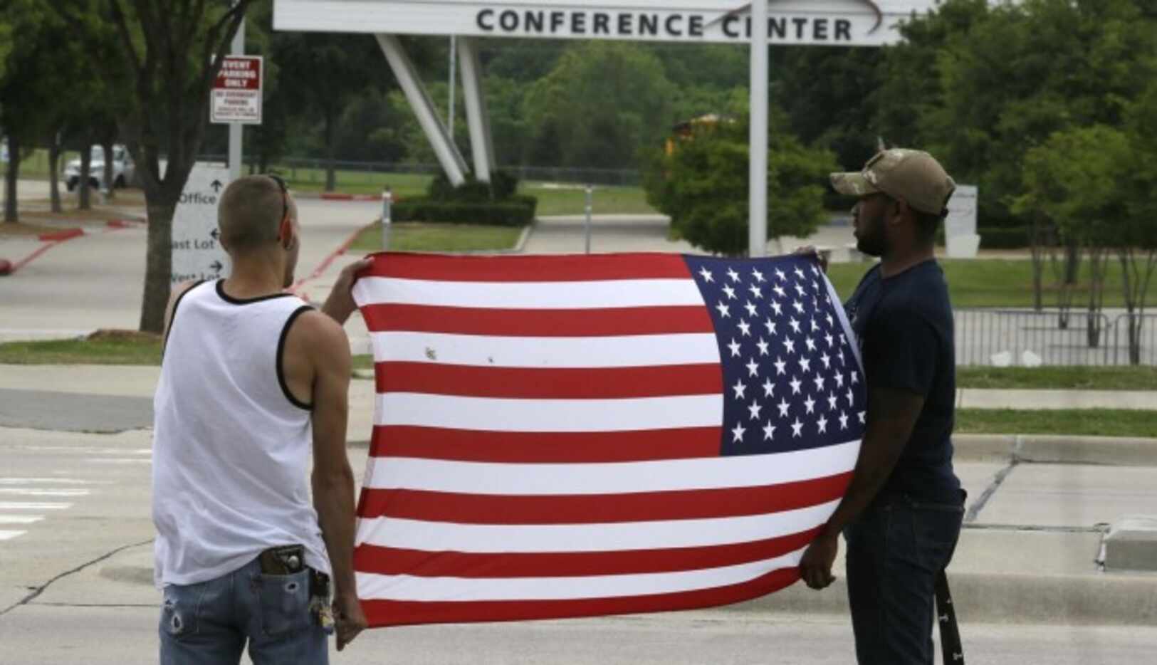 Joseph Offutt (der.) y Conner McCasland sostienen una bandera estadounidense enfrente del...