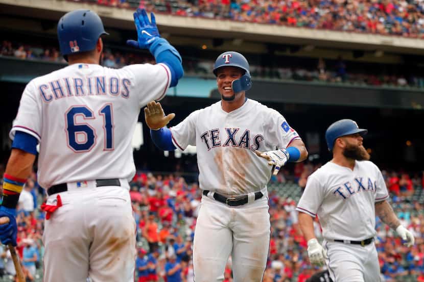 Texas Rangers Carlos Gomez (center) is congratulated by Robinson Chirinos (61) after scoring...