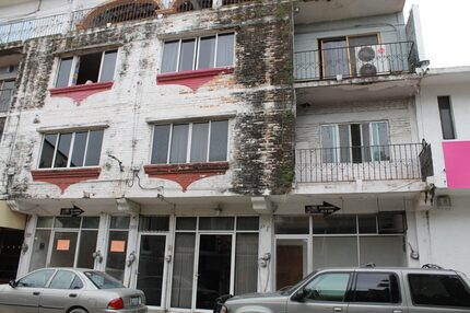 Cars sit parked in front of the apartment building where the Jalisco State prosecutor's...