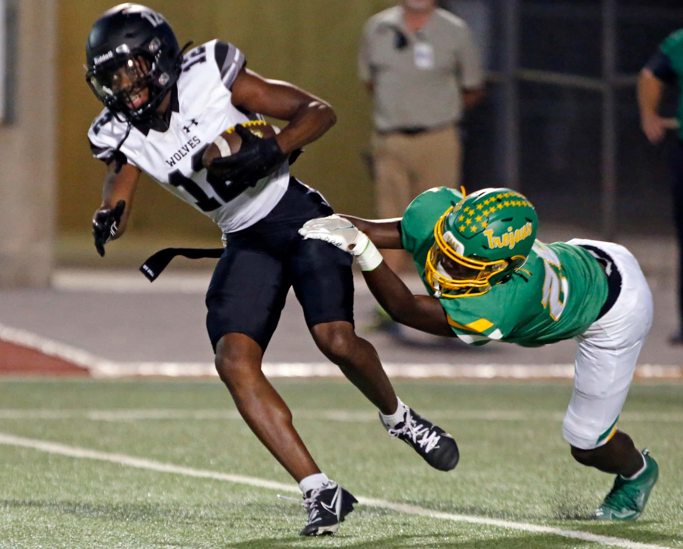 Mansfield Timberview high’s Elijah Pratt (12) tries to escape a tackle by a Newman Smith...