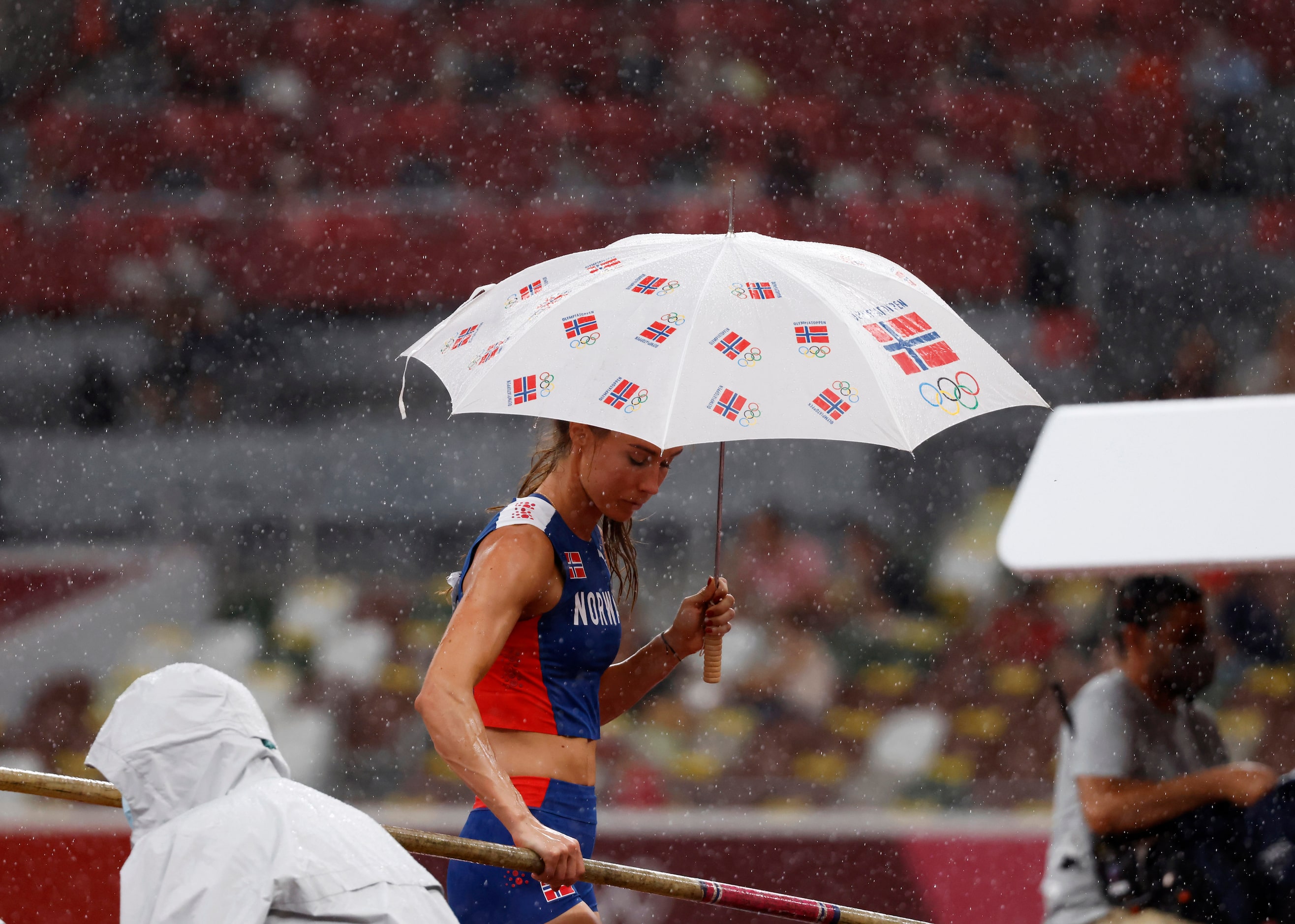 Norway’s Lee Onsrud Retzius keeps dry under an umbrella as she puts away her pole during a...