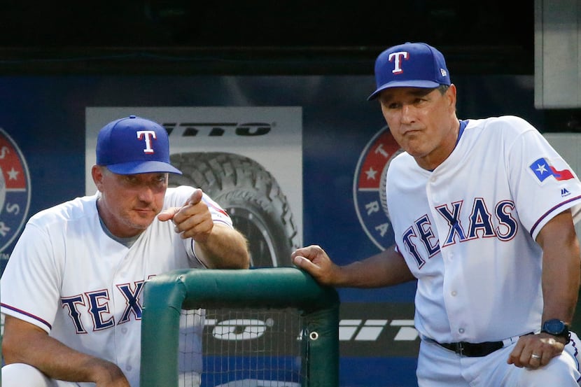 Texas Rangers manager Jeff Banister (28) and bench coach Don Wakamatsu (23) talk in the...