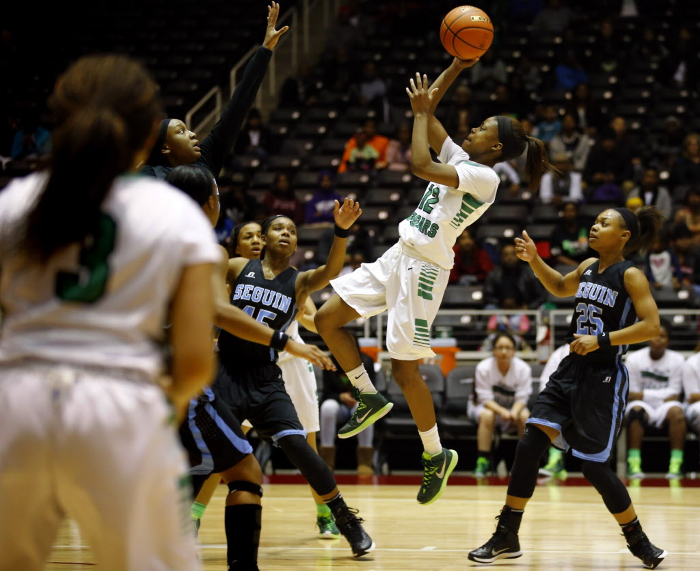 Bryan Adams' Alexxus Gilbert (12) goes up for the shot as she is surrounded by Arlington...