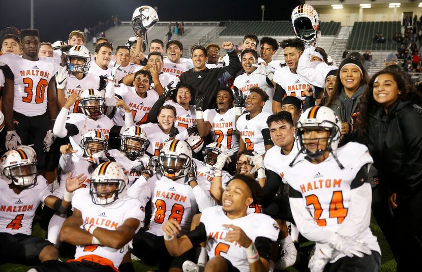 Haltom head coach Jason Tucker and his players pose for photographs with cheerleaders after...