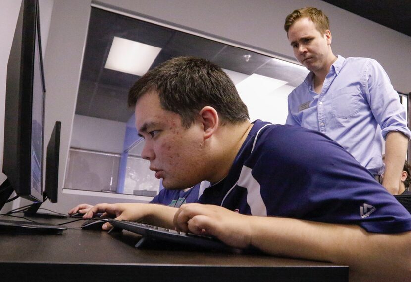 Kyle Barton (right), an instructor at the nonPareil Institute in Plano, works with Iain...