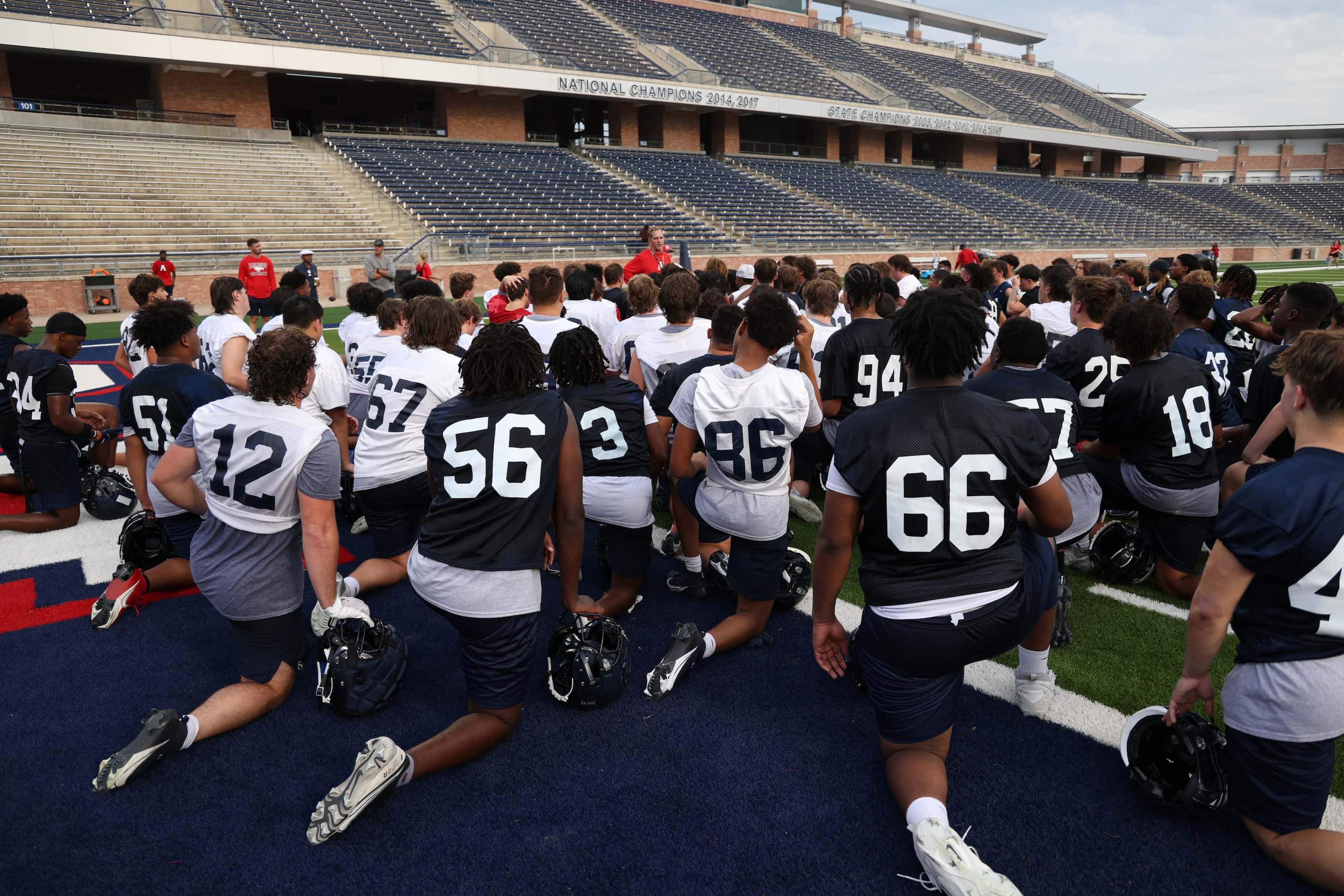 Allen head football coach Lee Wiginton, center background, offers feedback following his...