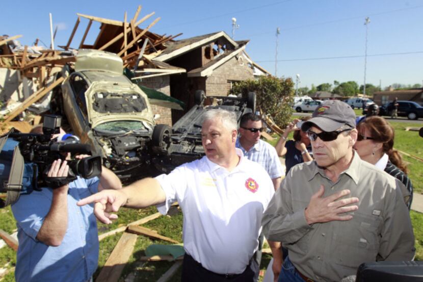 Lancaster Fire Chief Thomas Griffith points out tornado damage to Governor Rick Perry in...