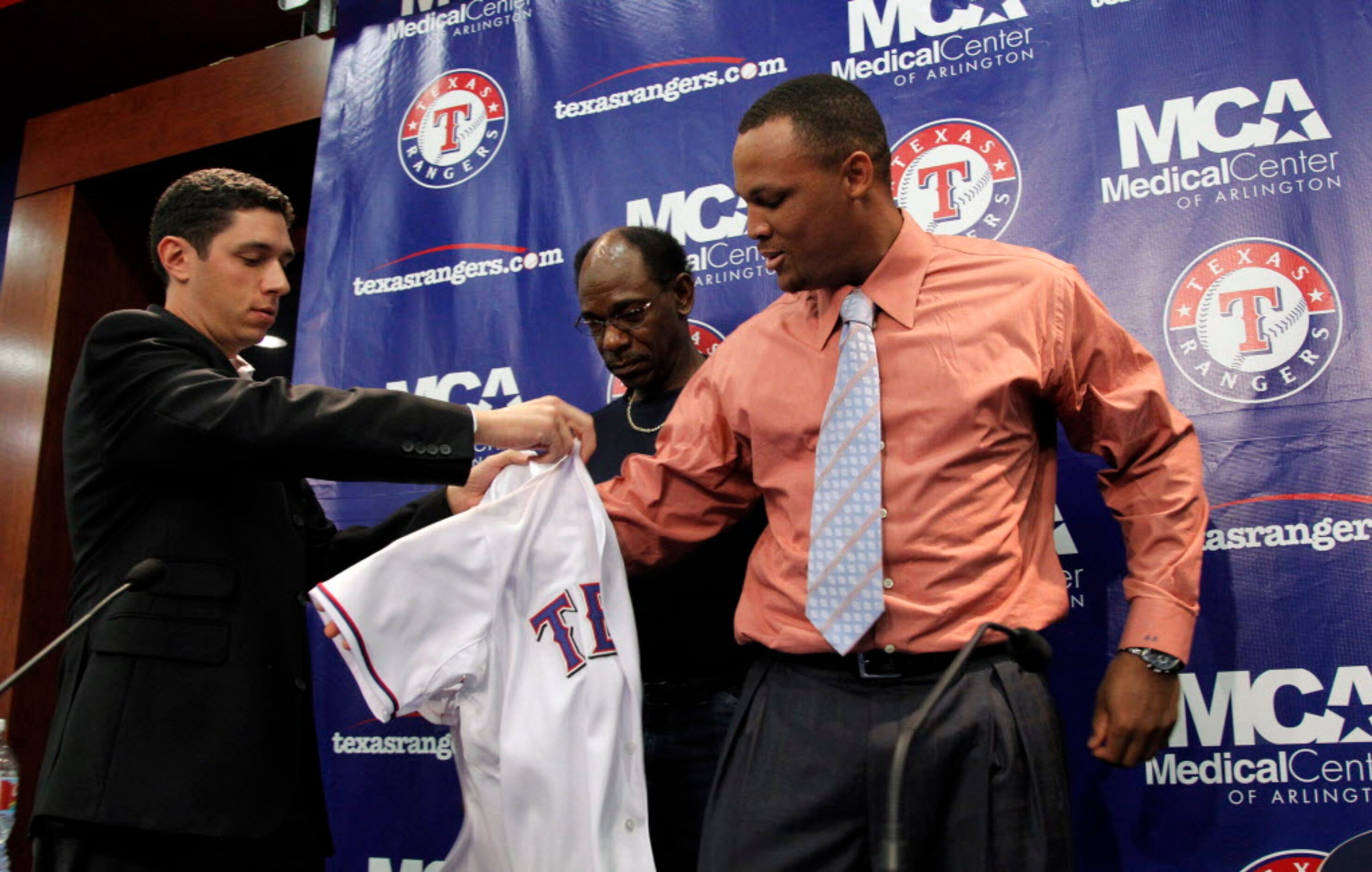 Ranger general manager Jon Daniels and manager Ron Washington hold a new jersey for Adrian...