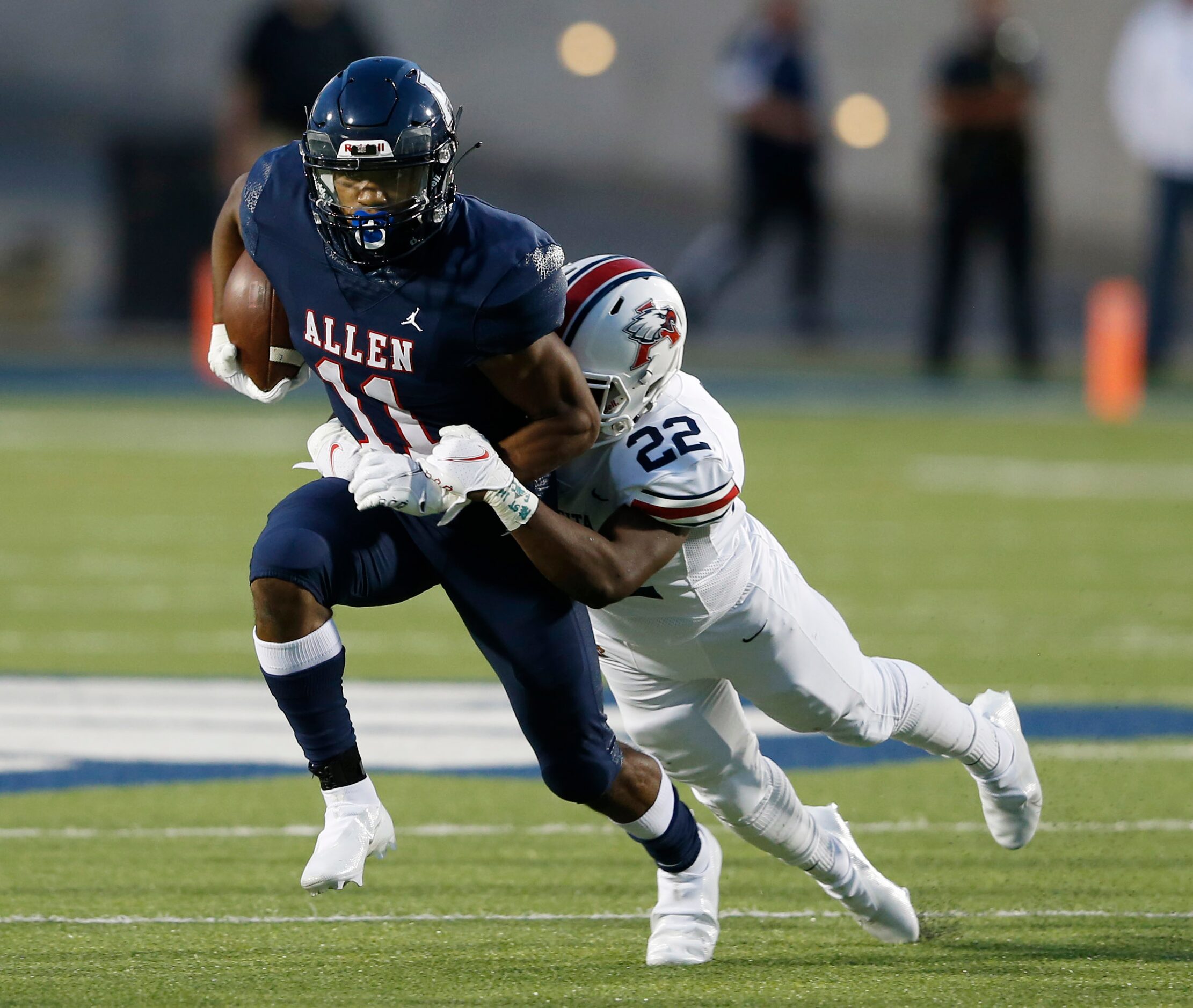 Allen's Jordan Johnson (11) is brought down by Humble Atascocita's Davon Bacon (22) during a...