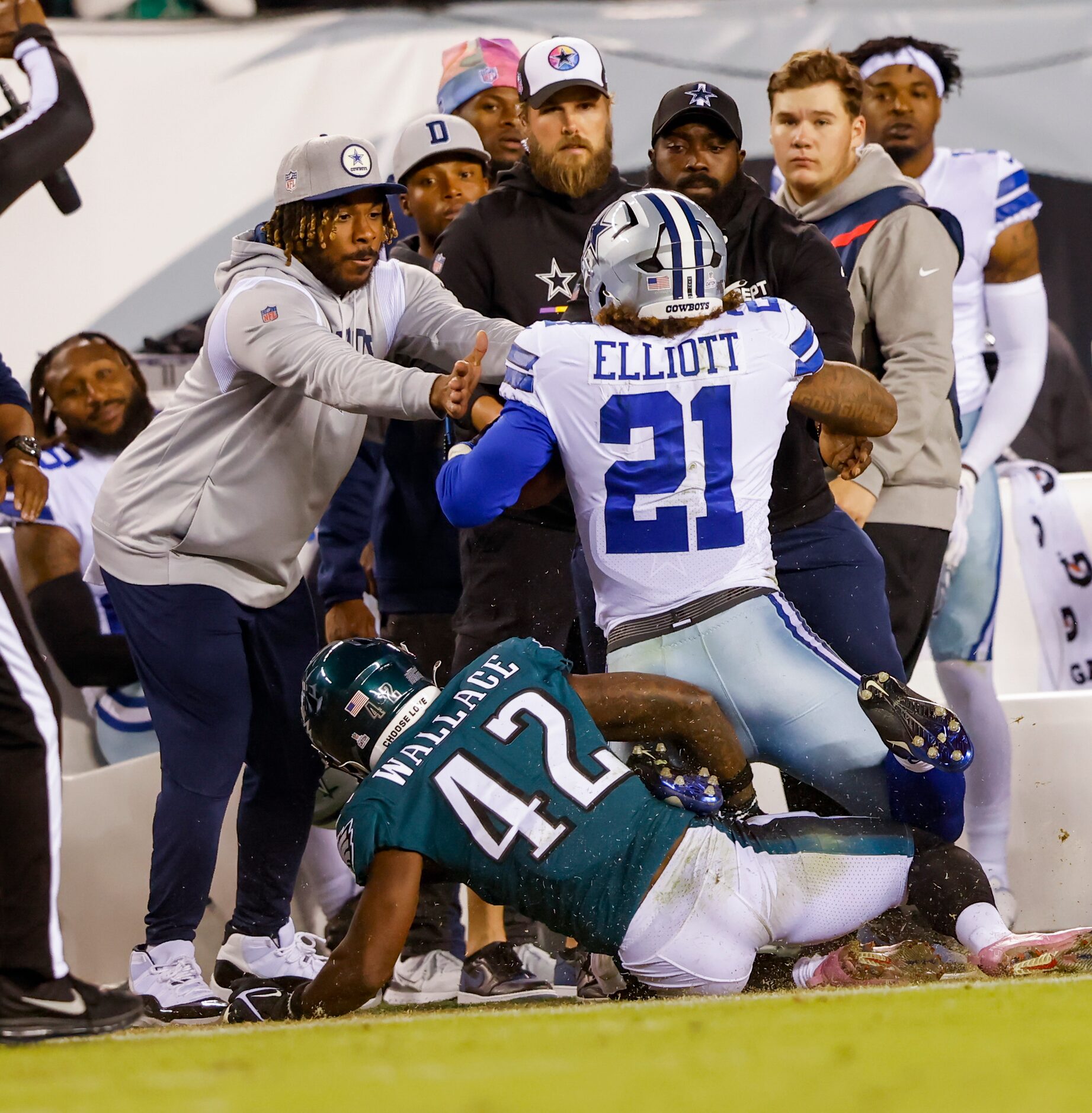 Dallas Cowboys running back Ezekiel Elliott (21) is pushed into the Cowboys sideline by...