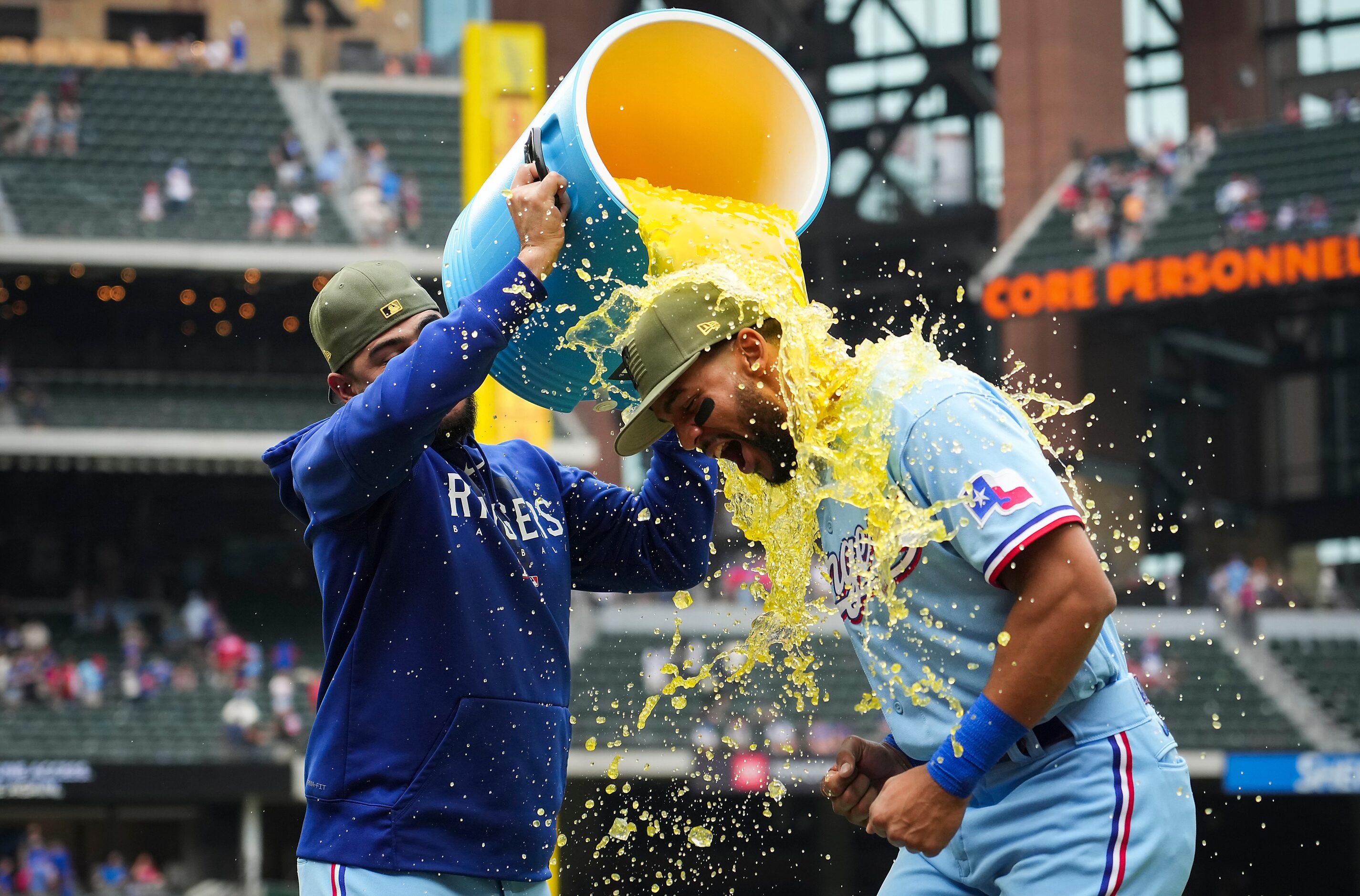 Texas Rangers center fielder Leody Taveras is dunked by starting pitcher Martin Perez after...