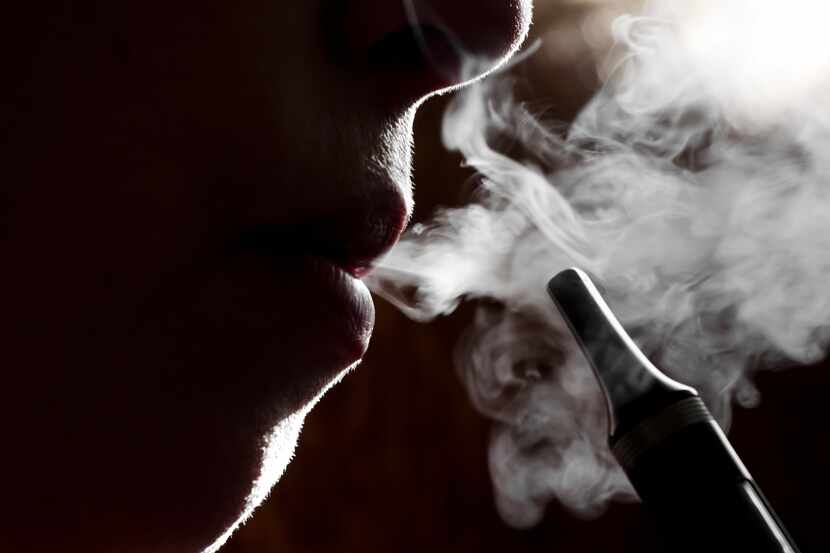 silhouette of a person vaping electric cigarette, close up. 
