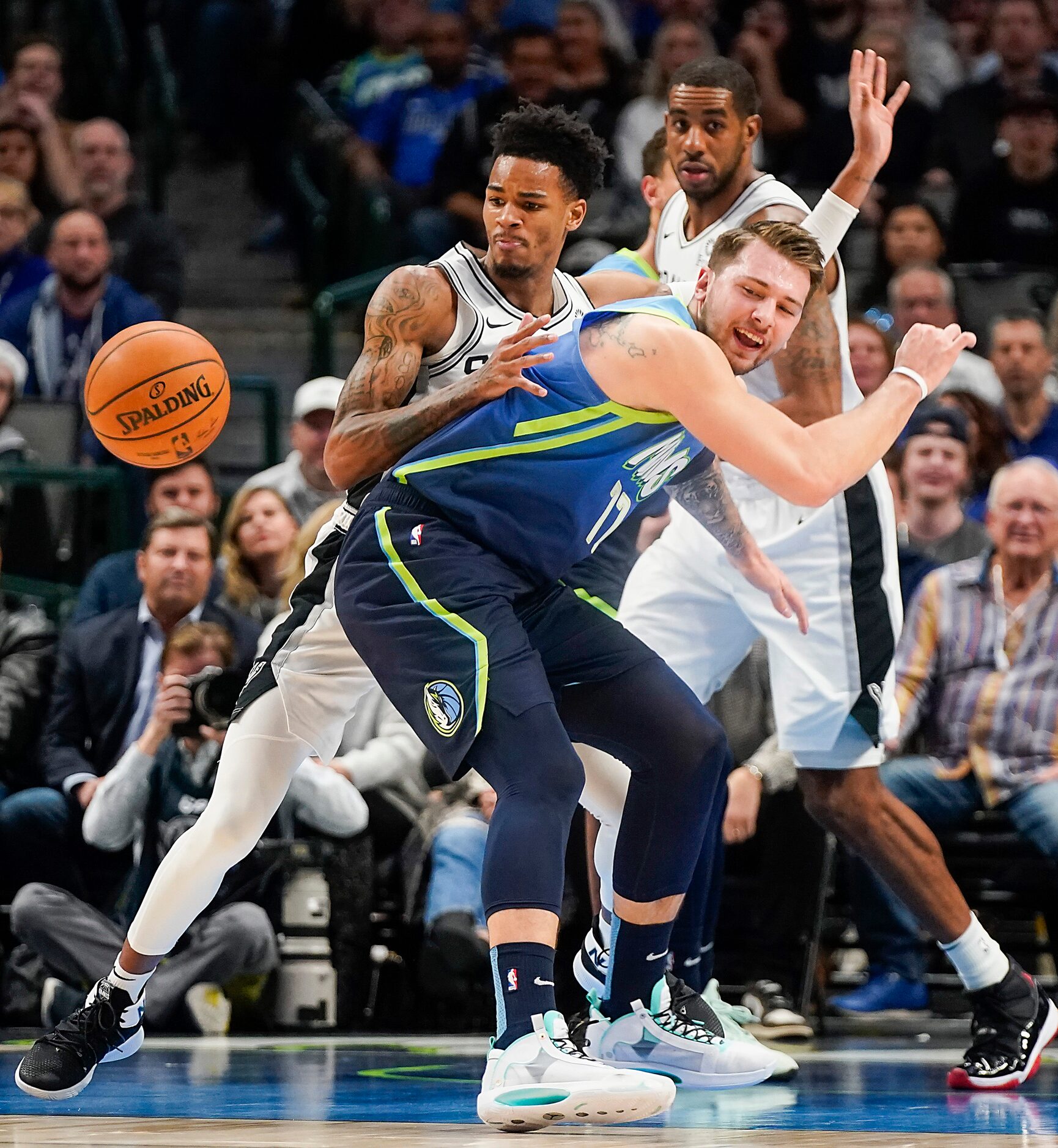 Dallas Mavericks guard Luka Doncic (77) is fouled by San Antonio Spurs guard Dejounte Murray...